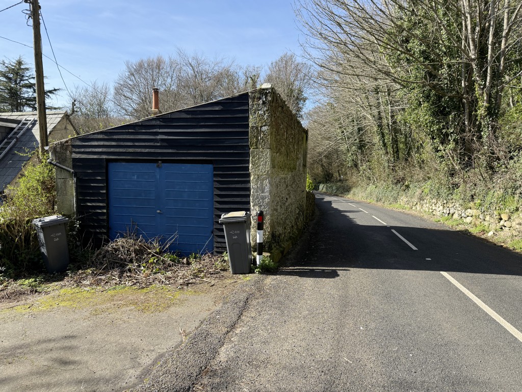 Lot: 52 - STRUCTURALLY DAMAGED DETACHED COTTAGE FOR IMPROVEMENT WITH GARAGE - View of detached garage and Undercliff Drive